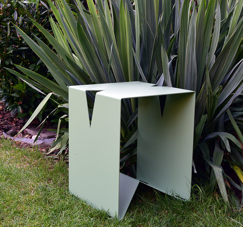 Shop the Look Beispiel mit einem blassgrünen Hocker aus gepulvertem Edelstahl, welcher draußen im Garten als Outdoor Möbel genutzt wird